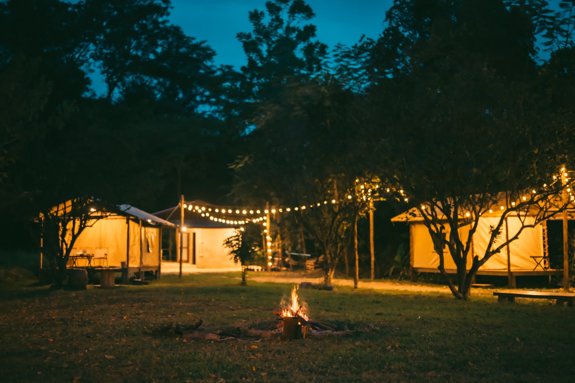 Cabins around a campfire at night